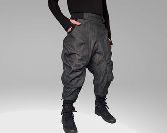 May include: Black denim cargo pants with a unique, gathered design. The pants have multiple pockets and a relaxed fit.