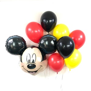 May include: A Mickey Mouse balloon bouquet with black, red and yellow balloons. The Mickey Mouse balloon is a foil balloon with a smiling face.