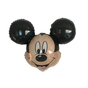 May include: A black and gold Mickey Mouse balloon with a smiling face. The balloon is shaped like Mickey Mouse's head with large black ears.