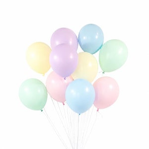 May include: A cluster of ten round balloons in soft pastel colors including light pink, pale yellow, lavender, mint green, and baby blue. Each balloon is attached to a thin white string, and they are arranged in a rounded, overlapping bunch.