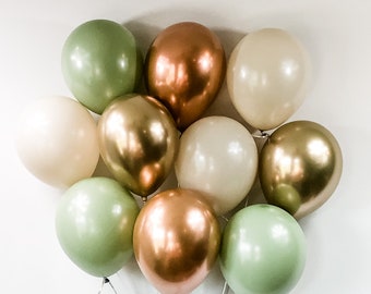 May include: A bunch of balloons in green, beige, and copper colors. The balloons are tied together with clear strings.