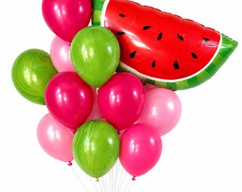 Puede incluir: Un ramo de globos que incluye un gran globo de aluminio con forma de rodaja de sandía en rojo, verde y negro, acompañado de varios globos de látex redondos en tonos rosa intenso, rosa claro y verde con un patrón de remolinos.