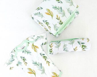 May include: A set of baby clothes featuring a white bodysuit with a green and yellow leaf pattern, a green and white patterned receiving blanket, and a matching green and white patterned burp cloth.