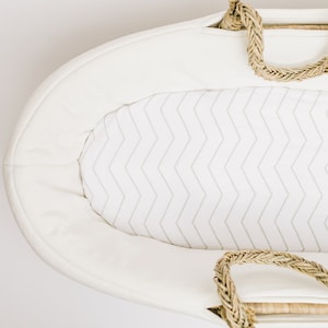 May include: White wicker bassinet with a white chevron patterned liner and rope handles.