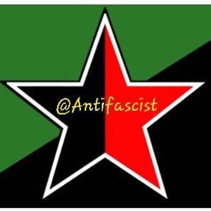 May include: A flag design featuring a large star divided into black and red halves, outlined in white. The background is split diagonally, with green on the left and black on the right. The text "@Antifascist" is in the center.