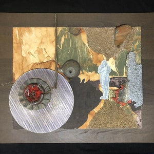 May include: A mixed media collage featuring a circular, silver-colored disc with a red center, a blue and white figure, and a brown, textured background.