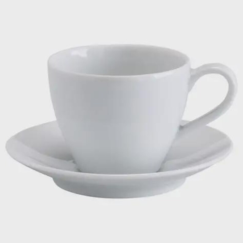 May include: A white ceramic teacup and saucer. The cup has a rounded form with a handle, and the saucer is a matching round plate. The set is plain white, ideal for serving tea or coffee.