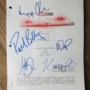Puede incluir: Una página de guion blanca con firmas azules y los logotipos de Marvel Studios y WandaVision. El guion se titula "THE PILOT" e incluye detalles sobre el estilo del episodio, como "1950s" y "Multicam".