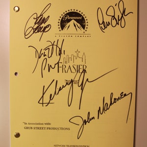 May include: A yellow script page from the TV show "Frasier" with signatures from the cast members, including Kelsey Grammer, John Mahoney, and Jane Leeves. The Paramount logo is at the top of the page.