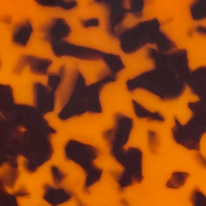 Puede incluir: Primer plano de un patrón de carey con colores marrón y naranja. El patrón es abstracto y se asemeja a un material natural.