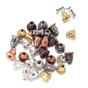 Può includere: Una collezione di chiusure per orecchini in varie finiture metalliche, tra cui oro, argento, rame e bronzo. L'immagine mostra le chiusure in diverse forme e dimensioni, con una chiusura dorata di 5 mm x 5,4 mm.