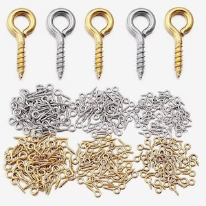 May include: A collection of metal screw eyes featuring a circular loop at one end and a threaded screw shank at the other. The set includes numerous individual pieces in both gold-tone and silver-tone finishes, arranged in piles.