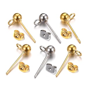 Peut inclure: Plusieurs boucles d'oreilles à clous dorées et argentées avec des fermoirs assortis. Les boucles d'oreilles ont un design simple, avec une petite boule au sommet d'une tige fine. Les fermoirs sont de type papillon.