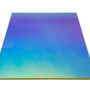 Puede incluir: Una hoja de papel holográfico iridiscente con un degradado de colores azul, verde y morado. El papel tiene un brillo sutil y un acabado liso y brillante.