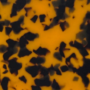 Puede incluir: Primer plano de un patrón de carey con un esquema de color amarillo y marrón. El patrón está formado por formas irregulares y remolinos.