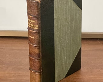 May include: A brown leather-bound book with gold lettering on the spine. The title is "Adventures of a Traveller Through the United States." The book has a green and black patterned cover.