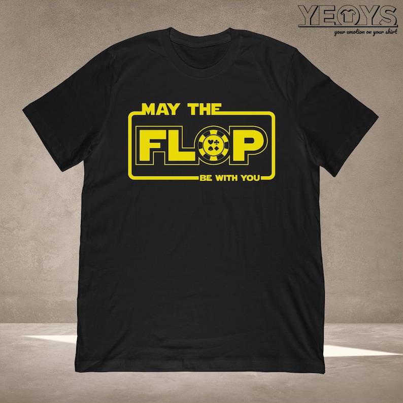 Puede incluir: Camiseta negra con un gr&aacute;fico amarillo que dice "Que el Flop est&eacute; contigo". El gr&aacute;fico presenta una ficha de p&oacute;quer con cuatro palos de cartas.