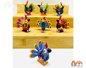 May include: Seven colorful wooden peacocks with intricate details and bright colors. The peacocks are arranged on a tiered wooden shelf.