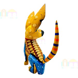 May include: A hand-painted wooden dog figurine with yellow, blue, orange, and red details. The dog is sitting with its tail curled up. The figurine is a traditional Mexican folk art piece.