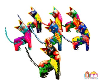 May include: A set of seven colorful wooden cat figurines, each painted with intricate floral designs in bright hues of blue, green, yellow, pink, and red. The cats are arranged in a circle, with their tails intertwined.