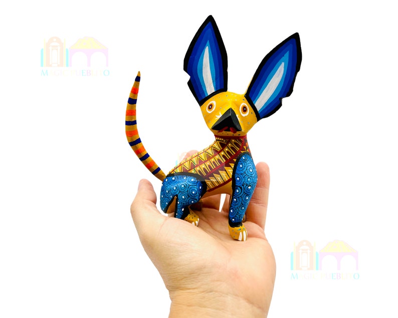 May include: A hand-painted wooden dog figurine with blue, yellow, and red details. The dog has large ears and a patterned body.