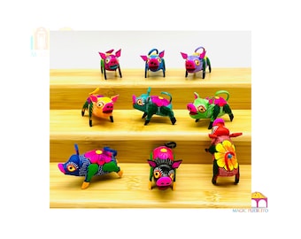 May include: Nine colorful hand-painted wooden pig figurines with floral accents. The pigs are arranged on two wooden shelves.