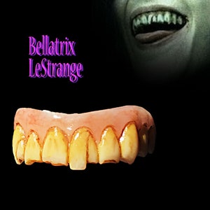 May include: A set of yellow and orange fake teeth with a pink gum line. The teeth are slightly crooked and have a worn appearance. The text "Bellatrix Lestrange" is visible in the background.