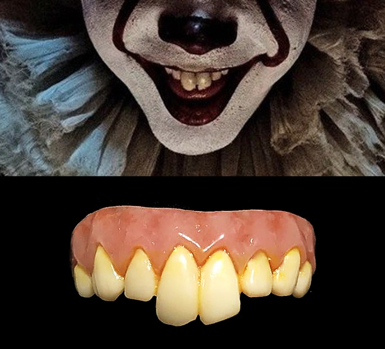 May include: A close-up of a smiling clown's face with white makeup and red accents. Below, a set of yellowed, fake teeth with a pink gum line are displayed against a black background. The teeth appear to be a costume prop.