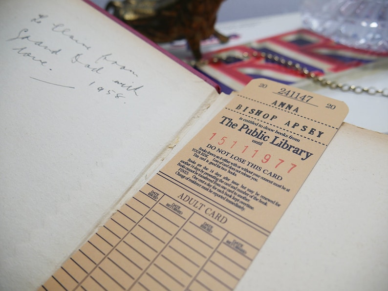 May include: A vintage library card from the Bishop Apsey Public Library in a tan color with black text. The card number is 241147 and the cardholder's name is Anna. The card is dated 15111977 and has a note that says "DO NOT LOSE THIS CARD".