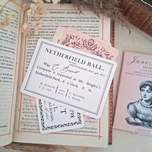 Op de afbeelding: Een rechthoekige witte kaart met zwarte gedrukte tekst die luidt NETHERFIELD BALL, HERTFORDSHIRE, NOV. 26th, 1813, Miss E. Bennet, Company is requested at Mr. Bingley's Netherfield Park, 6 o'clock, P. M., M. Judson, P. E. Lee, E. Walden, T. Wood.