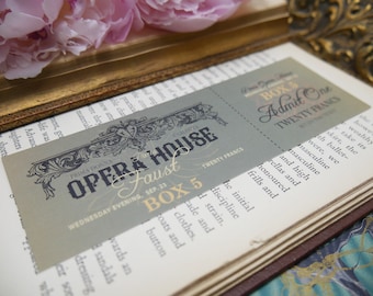 May include: A vintage-style ticket for the opera house, featuring the words "Opera House" and "Faust" in ornate lettering. The ticket is printed on a gray background with gold accents and reads "Wednesday Evening, Sep. 23, Box 5, Twenty Francs".