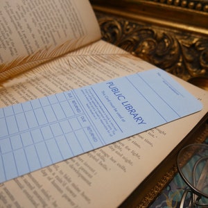 May include: A blue library card with the text "PUBLIC LIBRARY" and the words "This Card must be used at" printed on it. The card has a grid of columns labeled "DUE" and "RETURNED".