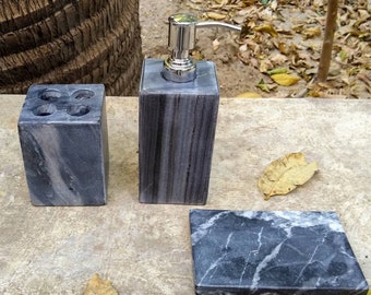 Può includere: Un set di tre accessori per il bagno in marmo grigio. Il set comprende un dispenser di sapone, un porta spazzolini da denti e un portasapone.