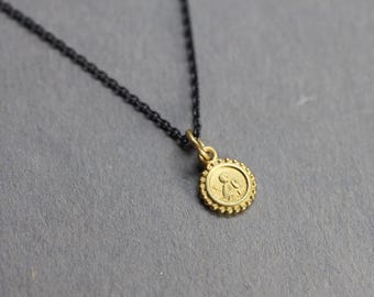Small guardian angel made of 18k gold with a blackened silver chain