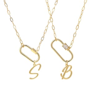 May include: Two gold necklaces with a carabiner style pendant. One pendant has a letter 'S' charm and the other has a letter 'B' charm.