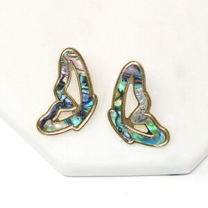 Pode incluir: Um par de brincos de borboleta de ouro com incrusta&ccedil;&otilde;es de madrep&eacute;rola de abalone iridescente. Os brincos s&atilde;o um design delicado e feminino.