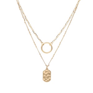 A set of double layered necklace in gold with a small disc and a hammered oval charms.