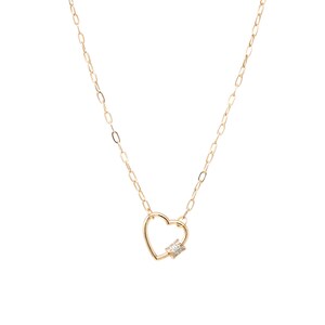 May include: A gold chain necklace with a heart-shaped pendant featuring a small, clear gemstone.