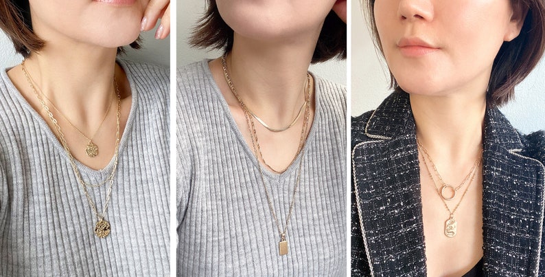 Wearing of multiple layered necklace sets in gold with small metal charms.