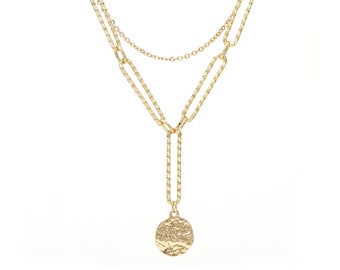May include: A gold layered chain necklace with a textured round pendant.
