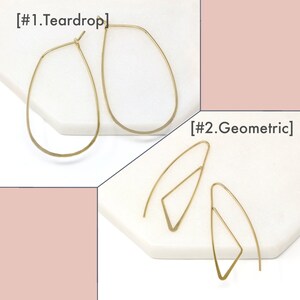 K&ouml;nnte beinhalten: Zwei Paar goldene Ohrringe. Das erste Paar ist tropfenf&ouml;rmig und das zweite Paar ist geometrisch. Die Ohrringe liegen auf einer wei&szlig;en Oberfl&auml;che. [#1.Teardrop] [#2.Geometric]