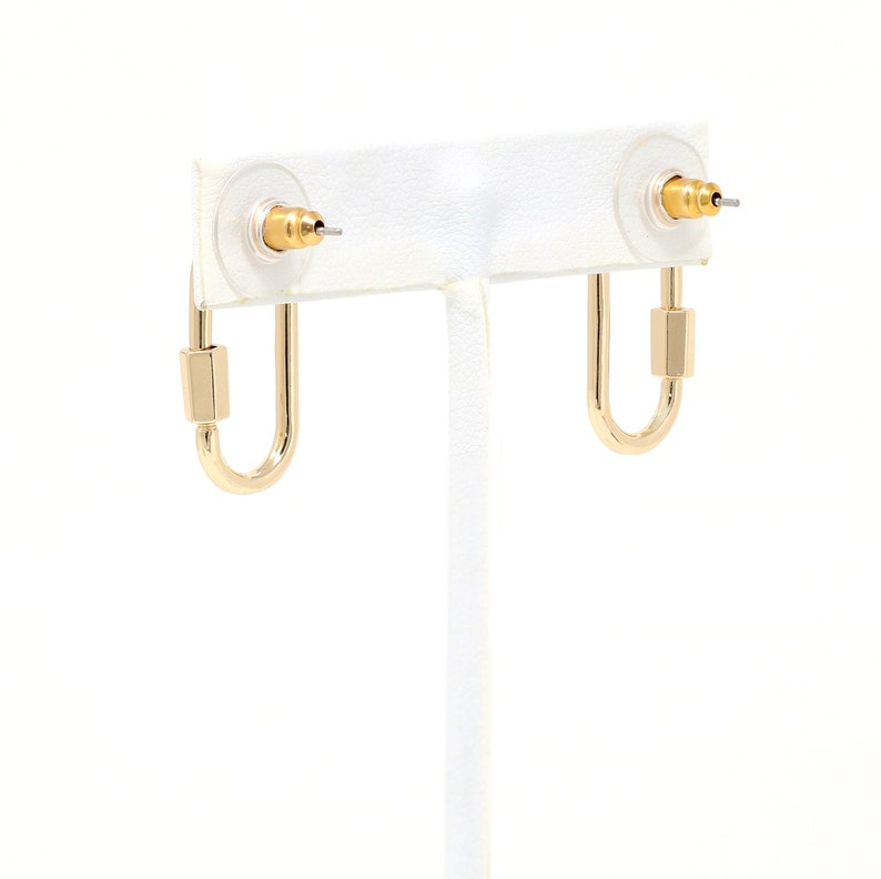 May include: A pair of gold hoop earrings with a square accent on the top of each hoop.
