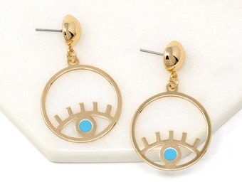 May include: Gold hoop earrings with a blue evil eye design. The earrings are dangling and have a post back.