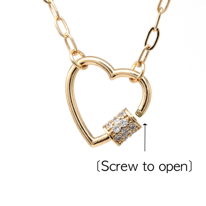 May include: Gold heart-shaped necklace with a screw-on clasp. The clasp is decorated with small clear rhinestones. (Screw to open)