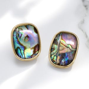 May include: A white ceramic mug with a black handle and the text "But First, Coffee" in a bold, black font. The mug is sitting on a wooden surface. The mug is approximately 4 inches tall.