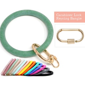 May include: Green glitter silicone bangle with a gold carabiner lock. The bangle is a keychain and can be worn as a bracelet.  Carabiner Lock Keyring Bangle.