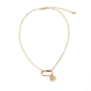 May include: A gold chain necklace with a gold carabiner clasp and a small gold disc charm with the letter "M" engraved on it.