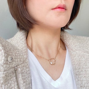 May include: A gold chain necklace with a heart-shaped pendant featuring a small, clear gemstone.