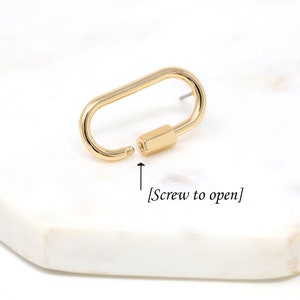 May include: Gold-toned metal lobster clasp with a screw closure. The clasp is open and the screw is visible. [Screw to open]
