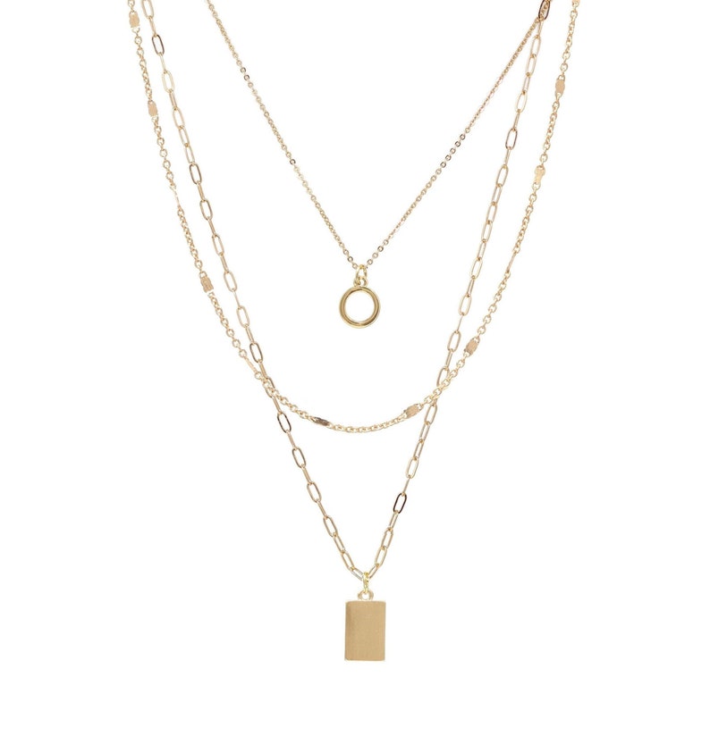 Triple layered modern charm necklace with detangler closure in gold.